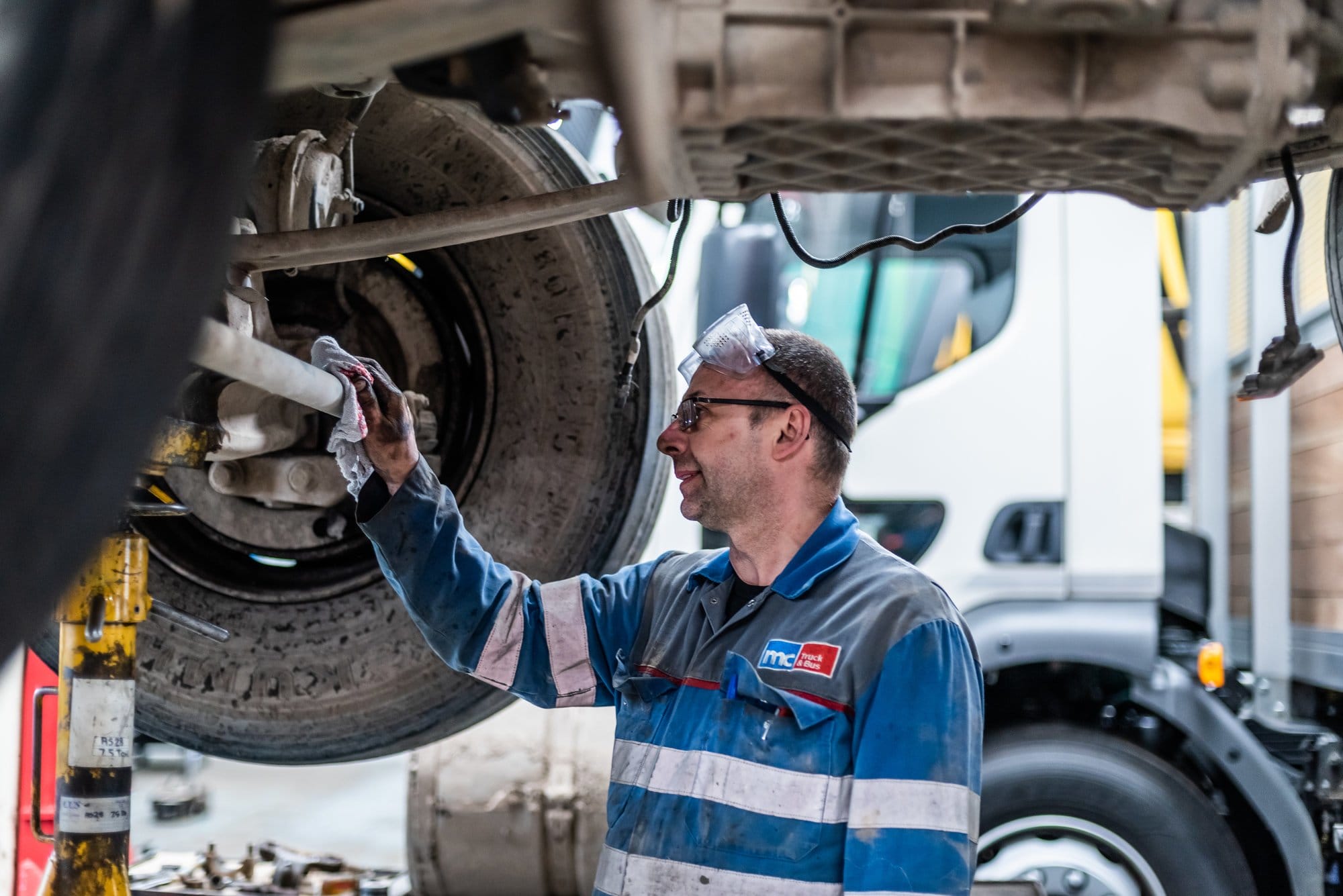mechanic using industrial rag to wipe a car