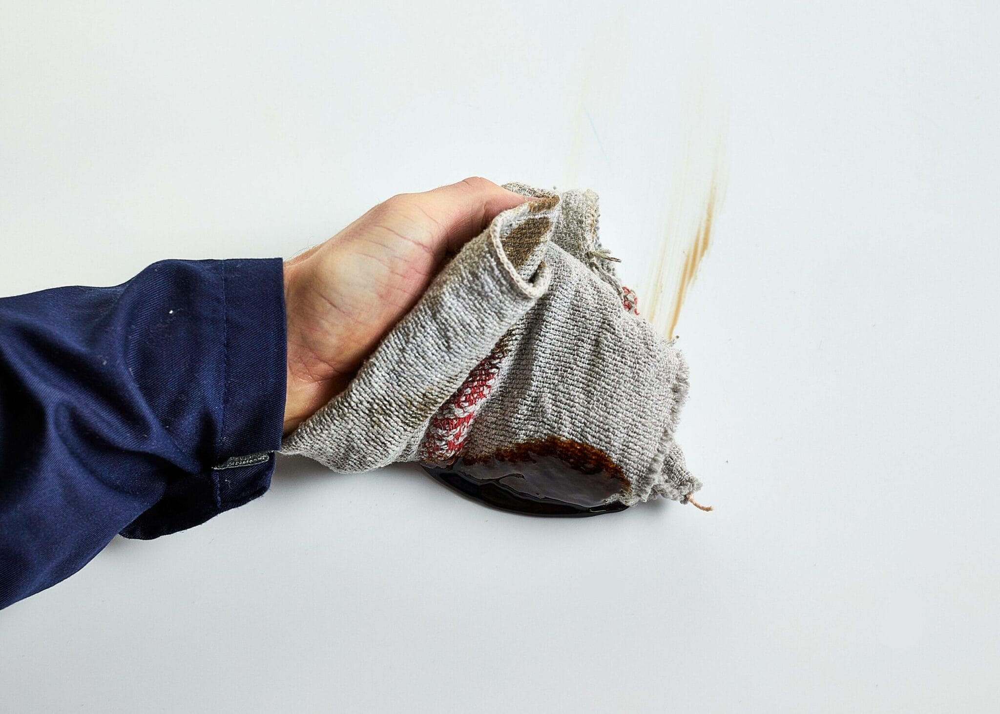 mechanic checking oil with industrial wiping rags
