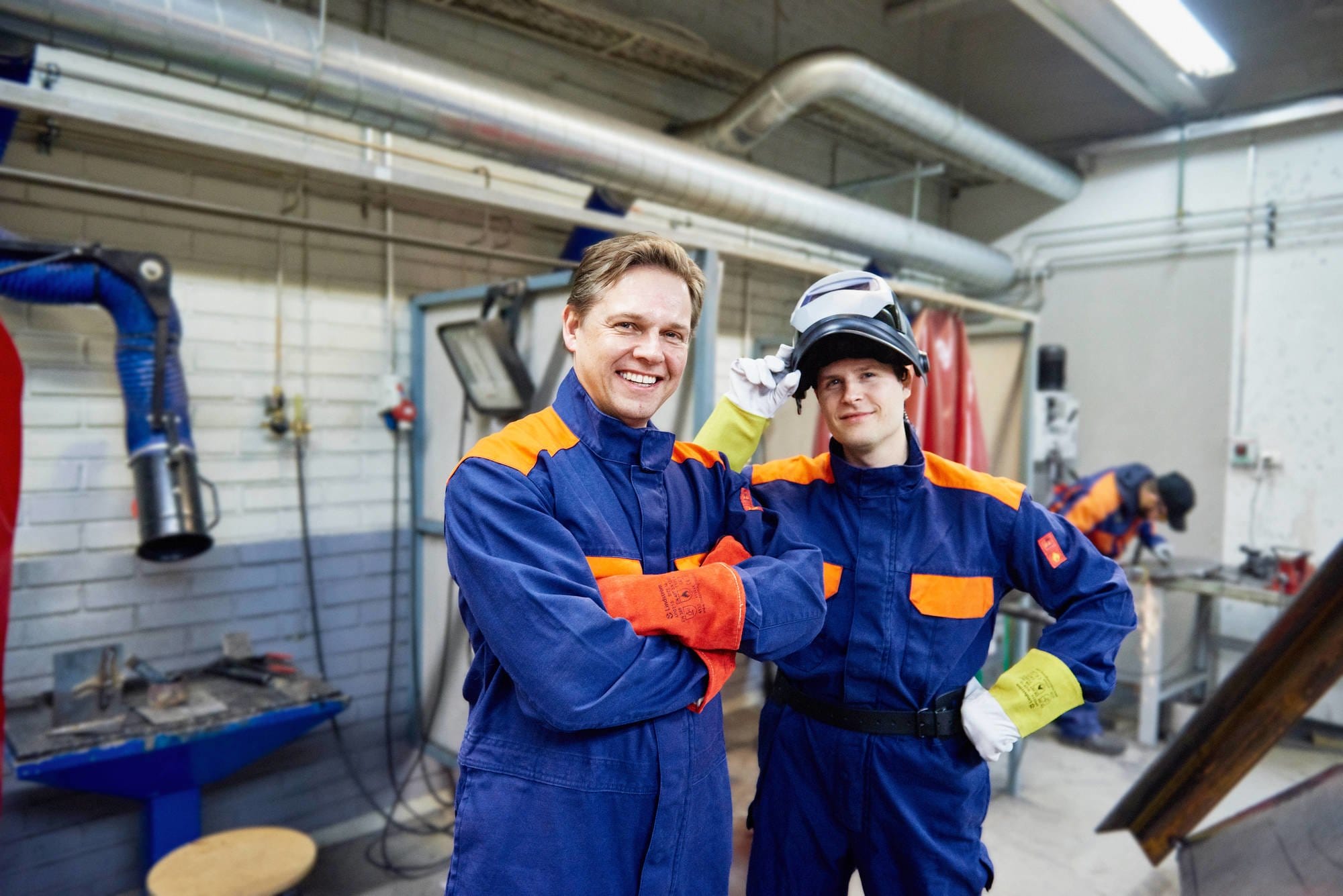 2 welders wearing protective flame retardant overalls