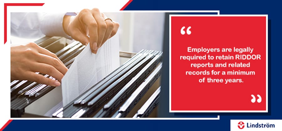 Documents are being filed in a cabinet, highlighting the legal requirement to retain RIDDOR reports for at least three years.
