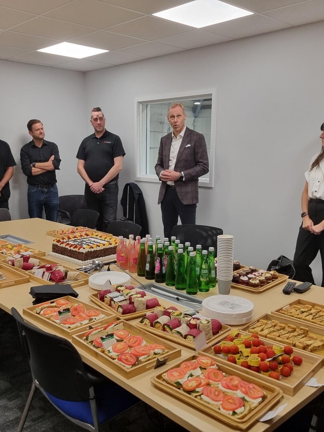 Lindström team celebrating the reopening of the refurbished Bedford office with a catered spread of food and drinks.