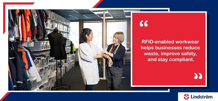 Staff measuring RFID-enabled workwear in uniform supply room for safety and compliance.