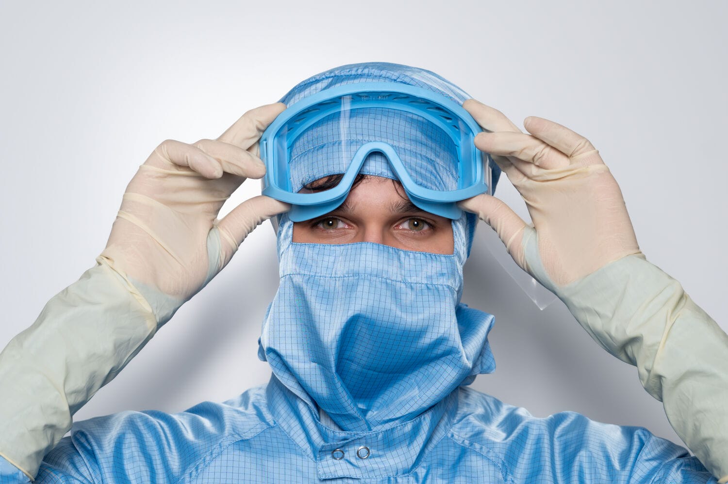 Cleanroom garments and goggles for lab safety.