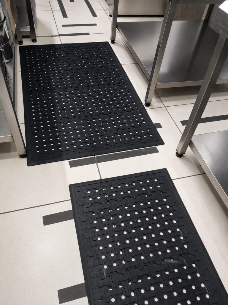 Üretim hattında ergonomik paspas üzerinde ayakta çalışan personel