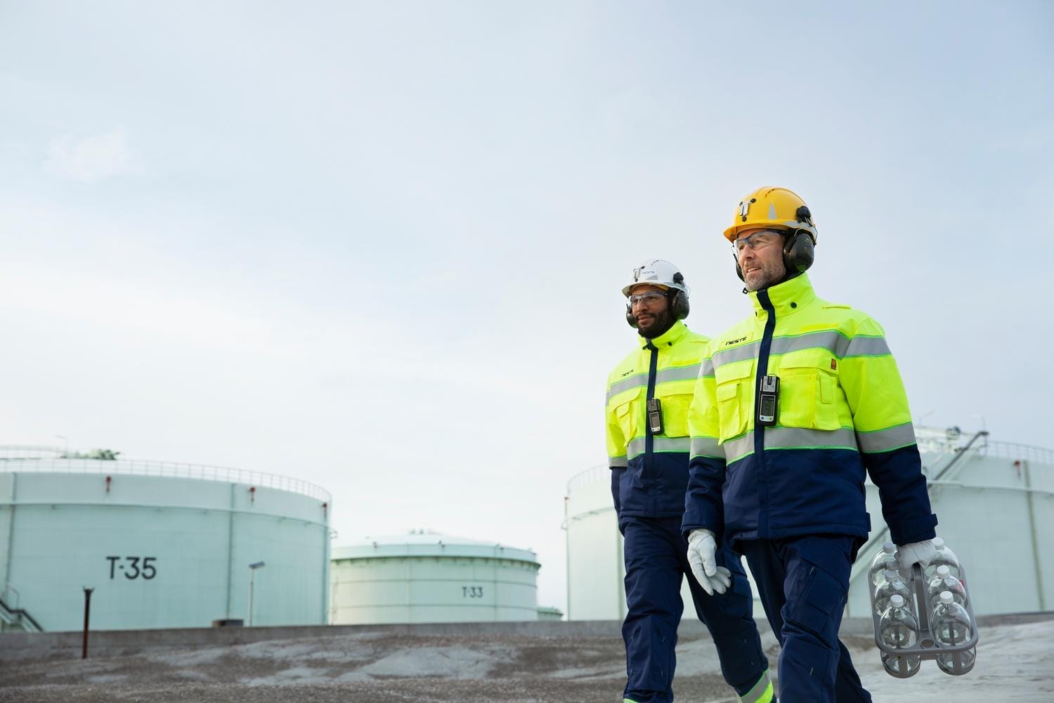 Neste employees wearing workwear walking in Porvoo refinery in Finland